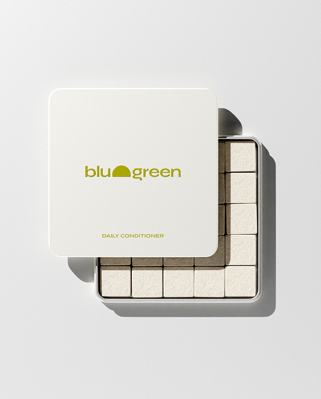 blu and green daily conditioner 50 cream-colored square tablets in a flat square tin with green-yellow logo. lid slightly off, studio, white ground, and strong light.